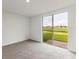 Bright bedroom with grey carpet and sliding glass door leading to backyard at 1357 Current Pl, Haines City, FL 33844