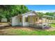 White house with a spacious porch and a detached shed at 5136 Mcdonald Rd, Zellwood, FL 32798