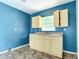 Small kitchen with light yellow cabinets and blue walls at 5136 Mcdonald Rd, Zellwood, FL 32798