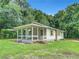 Charming white house with a covered porch and mature trees at 5136 Mcdonald Rd, Zellwood, FL 32798