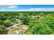 Aerial view showcasing a home surrounded by dense green trees and other houses nearby at 5136 Mcdonald Rd, Zellwood, FL 32798