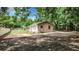 Tan house with one window, situated on a large lot with mature trees at 5136 Mcdonald Rd, Zellwood, FL 32798