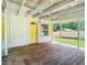 Spacious wooden front porch with yellow door and windows at 5136 Mcdonald Rd, Zellwood, FL 32798