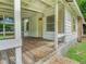 Wooden front porch with yellow door and windows at 5136 Mcdonald Rd, Zellwood, FL 32798