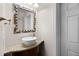 Powder room with pedestal sink, granite countertop and decorative mirror at 7576 Excitement Dr, Reunion, FL 34747