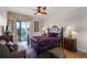 Bedroom with a purple comforter, wood floors, and access to a balcony at 7576 Excitement Dr, Reunion, FL 34747