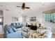 Spacious living room featuring comfortable sofas, a large TV, and a ceiling fan at 7576 Excitement Dr, Reunion, FL 34747