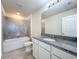 Modern bathroom with granite countertop, white cabinets, and gray tile at 1009 Rivers Crossing St, Clermont, FL 34714