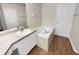 Bathroom with a garden tub, white vanity, and wood-look flooring at 205 Hibiscus St, Winter Haven, FL 33881