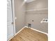 Laundry room with built-in shelving and wood-look flooring at 205 Hibiscus St, Winter Haven, FL 33881