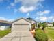 House exterior featuring a two-car garage and well-manicured landscaping at 205 Hibiscus St, Winter Haven, FL 33881