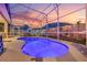 Relaxing pool and patio area with screened enclosure at sunset at 442 Ella Mae Dr, Davenport, FL 33897