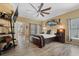 Spacious bedroom with wood flooring, ceiling fan, and large window at 442 Ella Mae Dr, Davenport, FL 33897