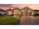 House exterior at dusk showcasing landscaping and driveway at 442 Ella Mae Dr, Davenport, FL 33897