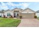 House exterior featuring a two-car garage and manicured lawn at 442 Ella Mae Dr, Davenport, FL 33897
