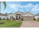 House exterior with a two-car garage and well-maintained lawn at 442 Ella Mae Dr, Davenport, FL 33897