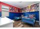Twin bedroom with Marvel-themed decor and wood-look floors at 5300 Oakbourne Ave, Davenport, FL 33837