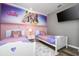 Two twin beds in a princess-themed bedroom with mural and TV at 5300 Oakbourne Ave, Davenport, FL 33837