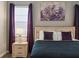 Bedroom with Queen bed, purple accents, and large art at 8834 Cabot Cliffs Dr, Davenport, FL 33896