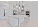 Modern white kitchen with island, stainless steel appliances, and glass pendant lights at 9832 Bucklow Hill Dr, Orlando, FL 32832