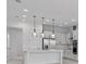 Modern white kitchen with island, stainless steel appliances, and glass pendant lights at 9832 Bucklow Hill Dr, Orlando, FL 32832