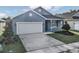 Newly built home with a gray exterior, white garage door, and a neatly landscaped yard at 530 Ellie Ct, Apopka, FL 32703