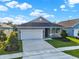 New single-story home with gray exterior, two-car garage, and landscaped lawn at 524 Ellie Ct, Apopka, FL 32703