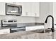 Modern kitchen features stainless steel appliances and granite countertops at 524 Ellie Ct, Apopka, FL 32703