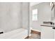 Clean bathroom with marble-look tile, granite vanity, and bathtub at 524 Ellie Ct, Apopka, FL 32703