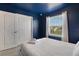 Blue bedroom with a full-size bed and white closet doors at 4270 Lana Ave, Davenport, FL 33897