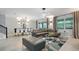 Open living room with sectional sofa, modern lighting, and dining area at 2726 Oxymoron Way, Kissimmee, FL 34746