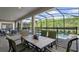 Covered patio area with outdoor dining furniture and a view of the pool at 2726 Oxymoron Way, Kissimmee, FL 34746
