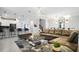 Open living room with sectional sofa, modern lighting, and kitchen views at 2726 Oxymoron Way, Kissimmee, FL 34746