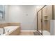 Clean bathroom featuring a soaking tub and a frameless shower at 2726 Oxymoron Way, Kissimmee, FL 34746