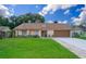 Ranch style home with brown roof, attached garage, and well-maintained lawn at 7628 Eldorado Pl, Orlando, FL 32818
