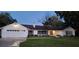 White two-car garage home with mature landscaping at 1030 Gregory Dr, Maitland, FL 32751