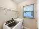 Laundry room with washer, dryer, and overhead shelving at 7574 Marker Ave, Kissimmee, FL 34747
