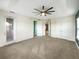 Main bedroom with ceiling fan, carpet, and access to balcony at 7574 Marker Ave, Kissimmee, FL 34747