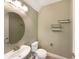 Powder room with sink, toilet, and round mirror at 7574 Marker Ave, Kissimmee, FL 34747