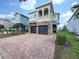 Two-story house with a two-car garage and brick paved driveway at 7574 Marker Ave, Kissimmee, FL 34747