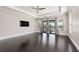Main bedroom with dark hardwood floors, large windows and access to a patio at 2490 Zuni Rd, St Cloud, FL 34771