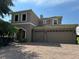 Two-story house with beige exterior, three-car garage, and a paver driveway at 2211 Rickover Pl, Winter Garden, FL 34787