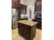 Kitchen island with granite countertop and dark wood cabinets at 2211 Rickover Pl, Winter Garden, FL 34787