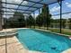 Inviting pool and spa with screened enclosure and lake view at 2211 Rickover Pl, Winter Garden, FL 34787