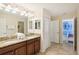 Bright bathroom with double sinks, granite countertops, and access to other rooms at 1431 Wexford Way, Davenport, FL 33896
