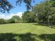 Green pasture bordered by trees and fence at 17530 Fosgate Rd, Montverde, FL 34756