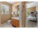 Bathroom with double vanity, toilet and shower, view into bedroom with bunk beds at 8101 Coconut Palm Way # 203, Kissimmee, FL 34747