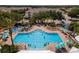 Aerial view of resort-style pool with surrounding lounge chairs and landscaping at 8101 Coconut Palm Way # 203, Kissimmee, FL 34747