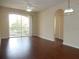 Living room with dark hardwood floors and sliding doors to balcony at 6214 Stevenson Dr # 201, Orlando, FL 32835