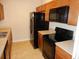 Galley kitchen with black appliances and wood cabinets at 6214 Stevenson Dr # 201, Orlando, FL 32835